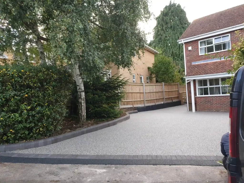 Large grey resin driveway with a black stone edge