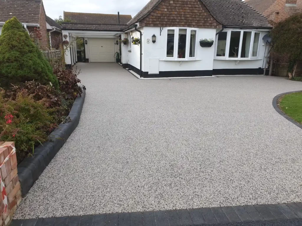 A newly installed light grey resin driveway