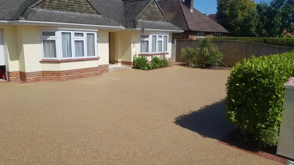 Large yellow resin-bound driveway surrounding a bungalow